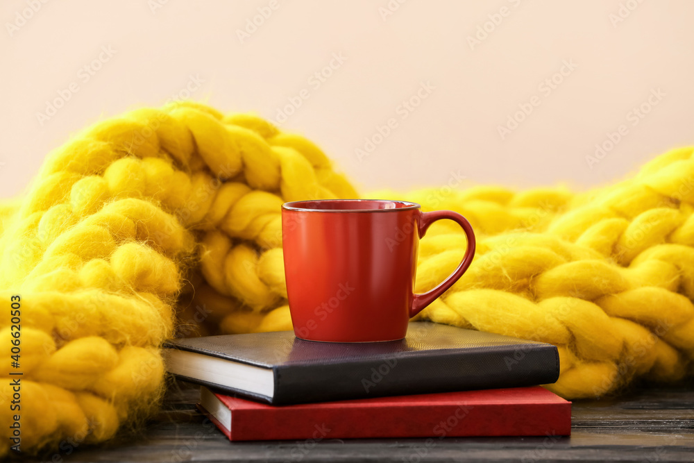 一杯茶，桌上摆着书和编织格子布