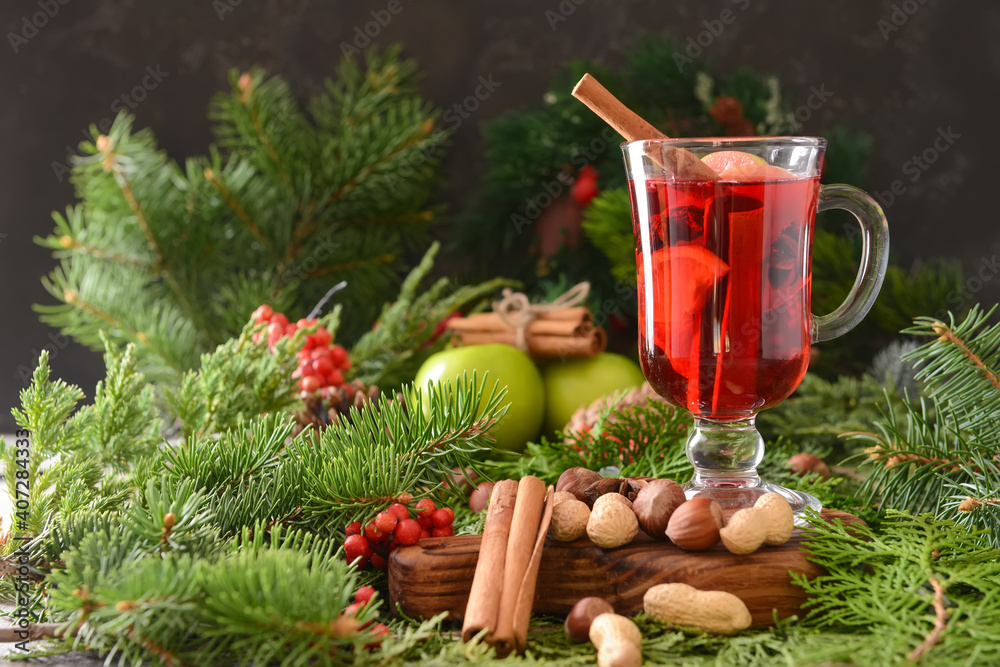 美味的热葡萄酒，在圣诞树枝上的玻璃杯中加入肉桂