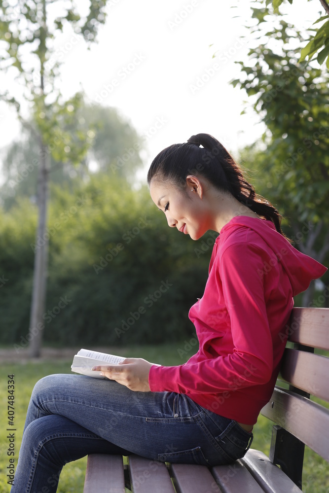 年轻女子在户外看书