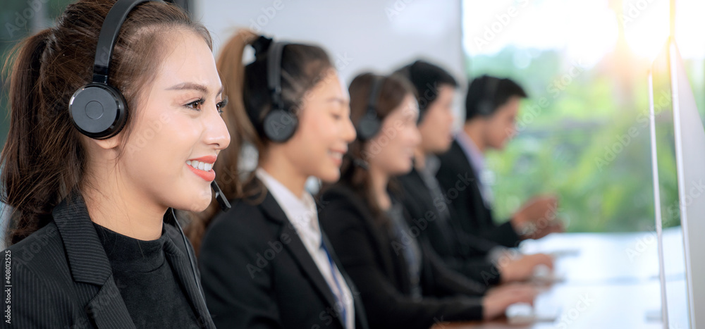 积极的亚洲女性客服代理，带耳机工作