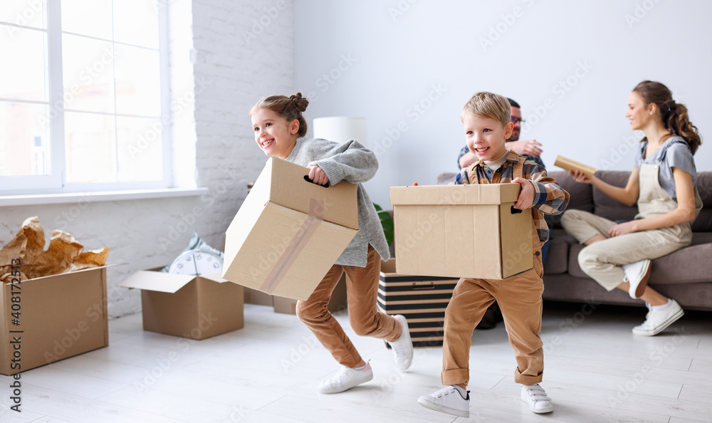 搬到新公寓和抵押贷款的概念。孩子们笑着拿着箱子到处跑