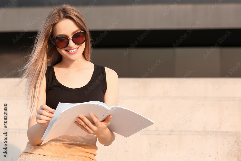 美女在户外阅读空白杂志