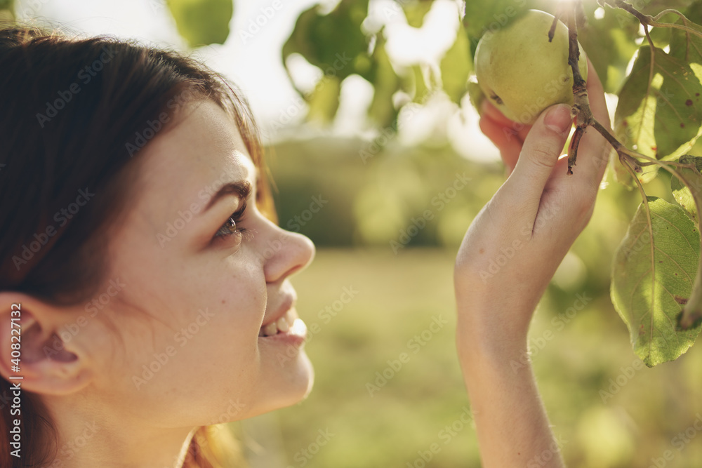 在花园近景中拍摄的大自然中带着苹果的女人的肖像