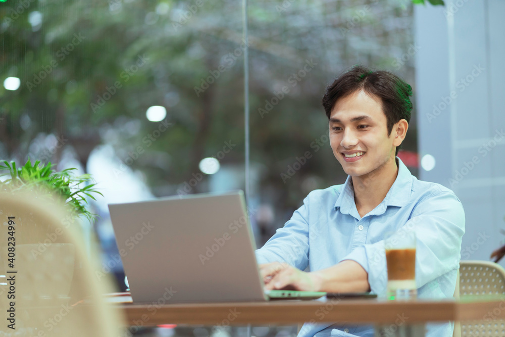 Asian man sitting working alone at a coffee shop
