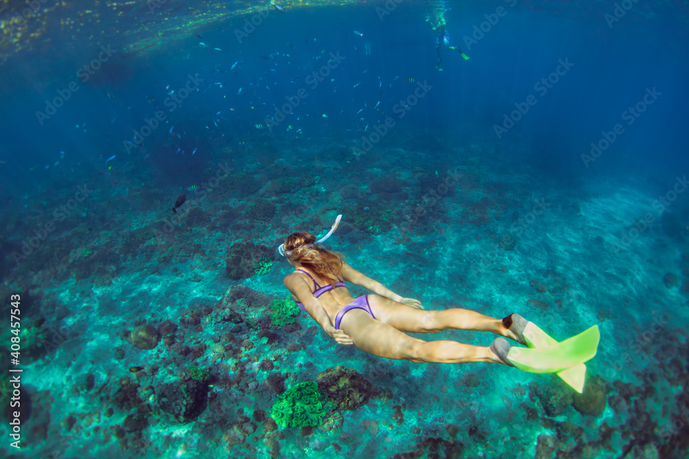 活跃的十几岁女孩在热带珊瑚礁游泳池跳水下。旅行生活方式，水上运动