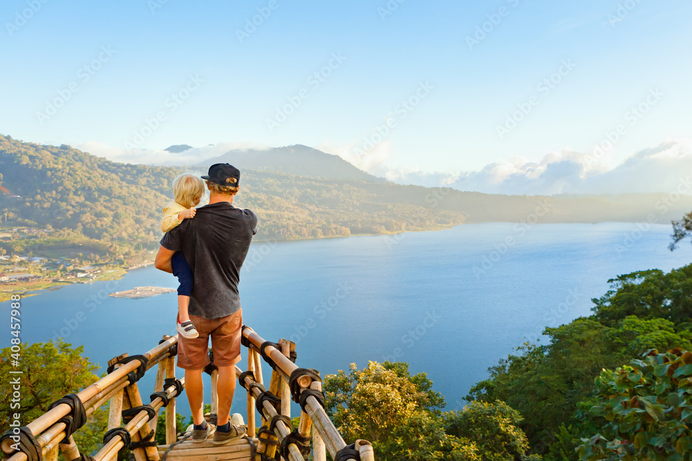 暑期家庭度假。年轻的父亲带着年幼的儿子站在高高的悬崖上的阳台上。孩子看起来很开心