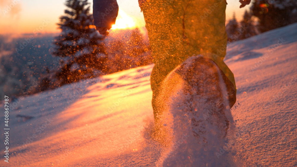低角度：日落时，当人们沿着雪地奔跑时，雪花闪闪发光。