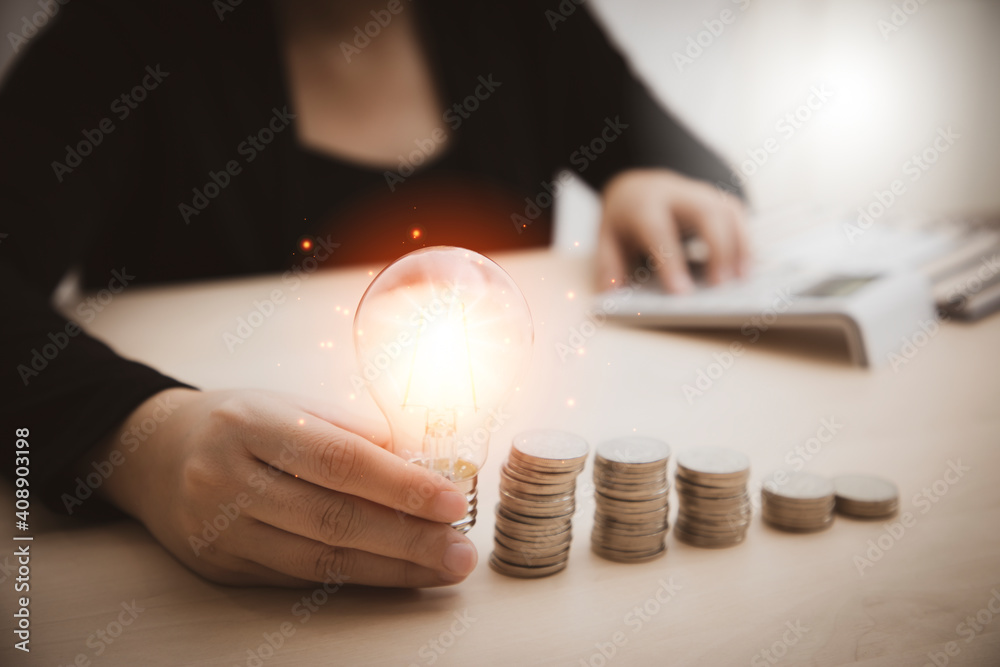 Business woman hand holding light bulb and working with computer on the desk, Creativity and innovat