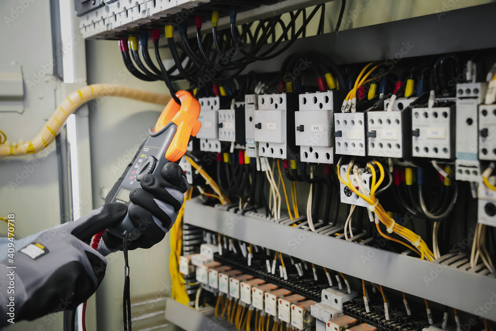 电气工程师测试保护继电器上的电气装置和接线，测量其w