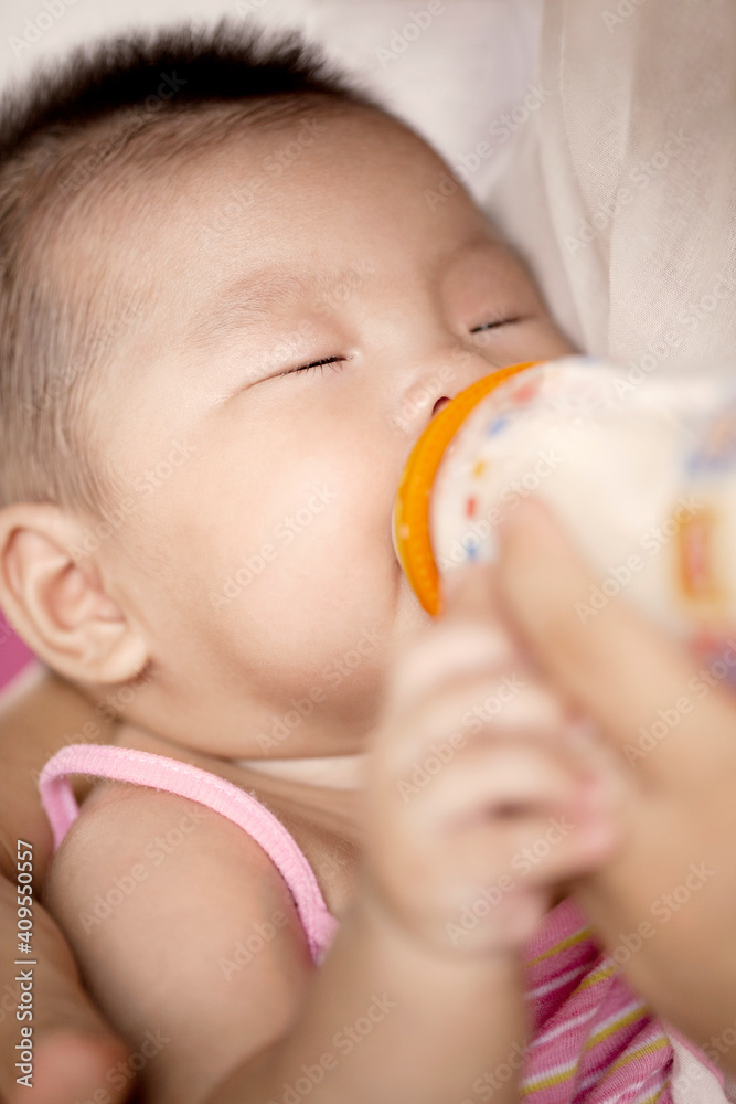 母亲用奶瓶给女婴喂奶