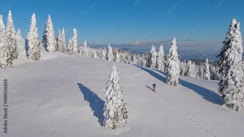 航空航天：女性游客在斯洛文尼亚滑雪旅行中徒步登上雪山