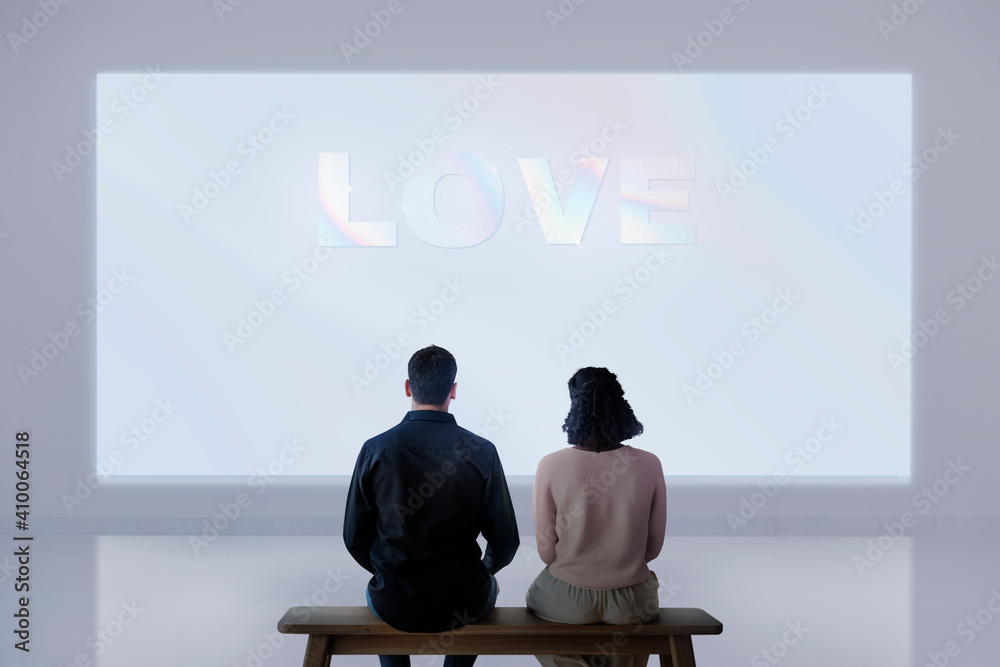 Couple watching  love movie projecting on the wall rear view