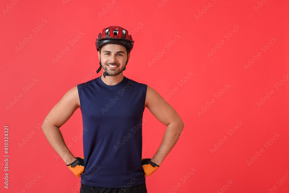 Male cyclist on color background