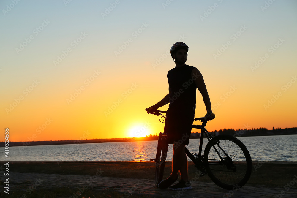 夕阳下骑自行车的男性骑手剪影