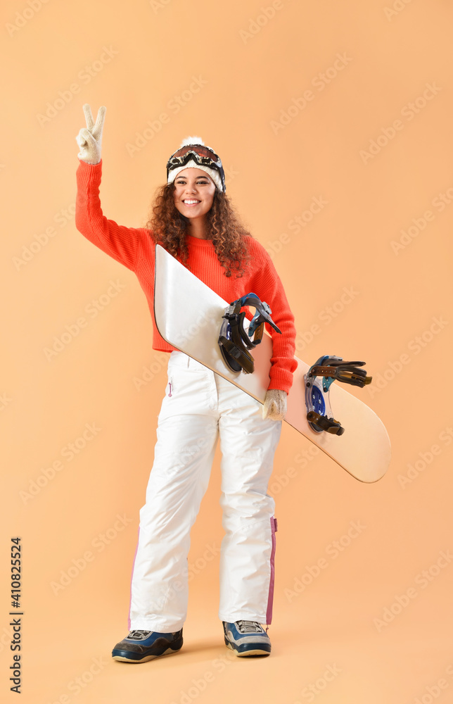 女单板滑雪运动员在彩色背景上展示胜利手势