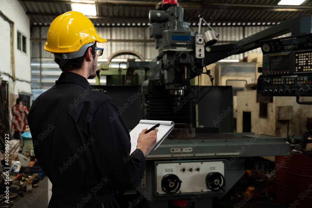 熟练的工厂工人用剪贴板做工作程序检查表。工厂生产li