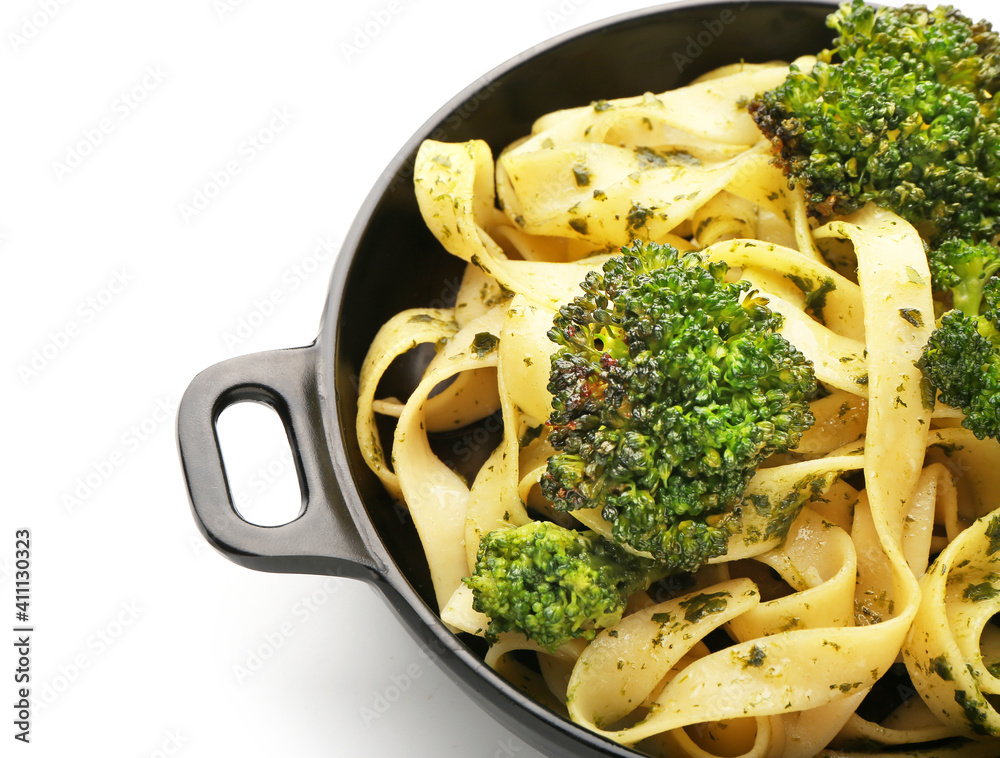 煎锅，白底配美味的意大利面和西兰花，特写