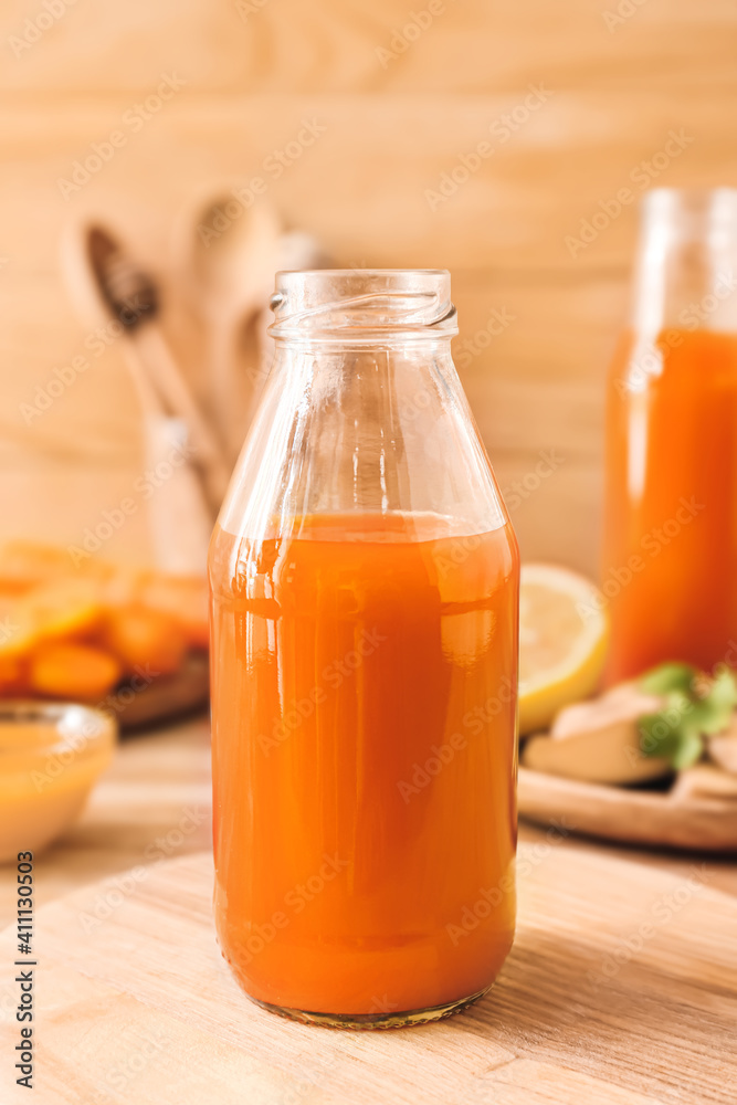 木桌上放着美味的胡萝卜汁的瓶子