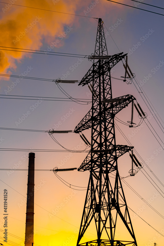 橙色和黄色日落下的输电塔。能源分配网络。选择性聚焦。