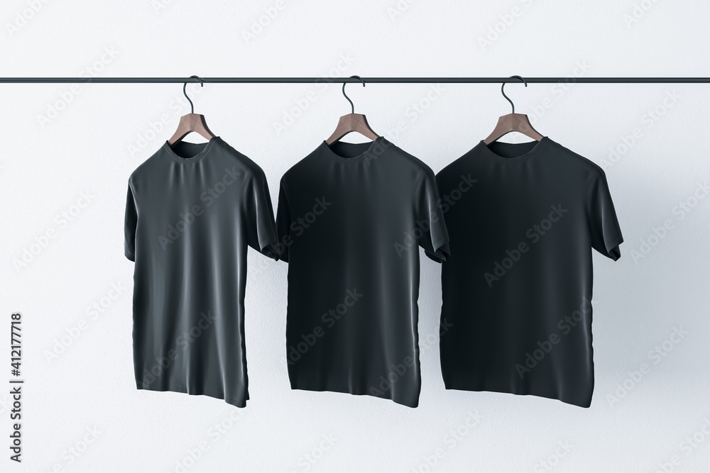 用三件白色背景的空白黑色t恤挂在栏杆上，制作一个标志概念。实物模型。3