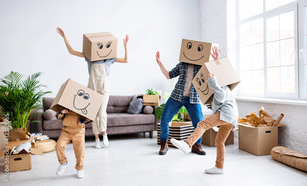 Cheerful family in carton boxes having fun during relocation