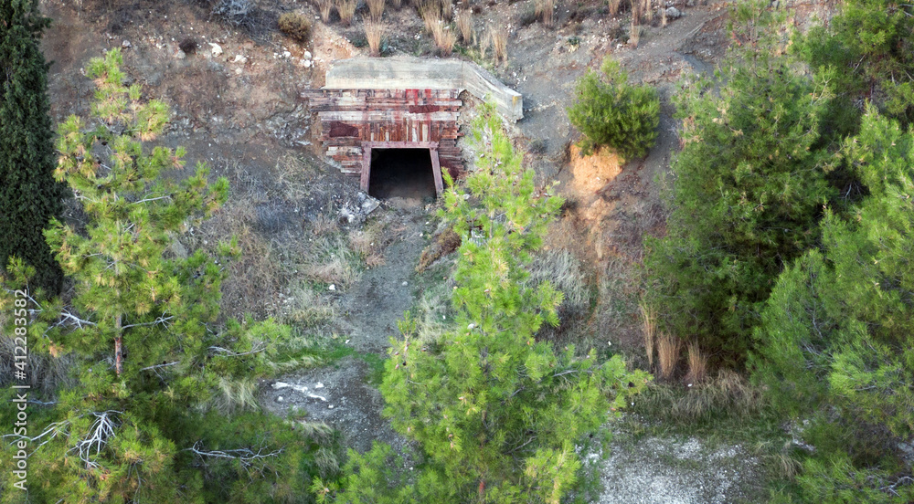 隐藏在树后的旧废弃矿井的开放式入口，鸟瞰图
