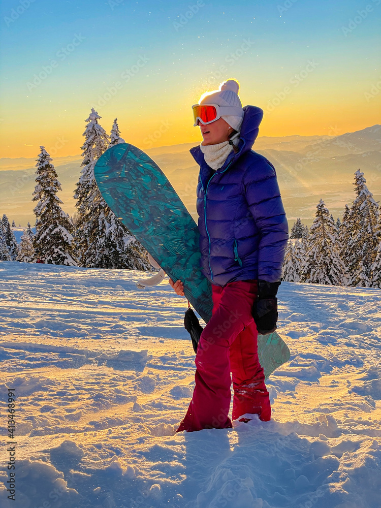 特写：适合女性游客在日落时用滑雪板登上雪坡