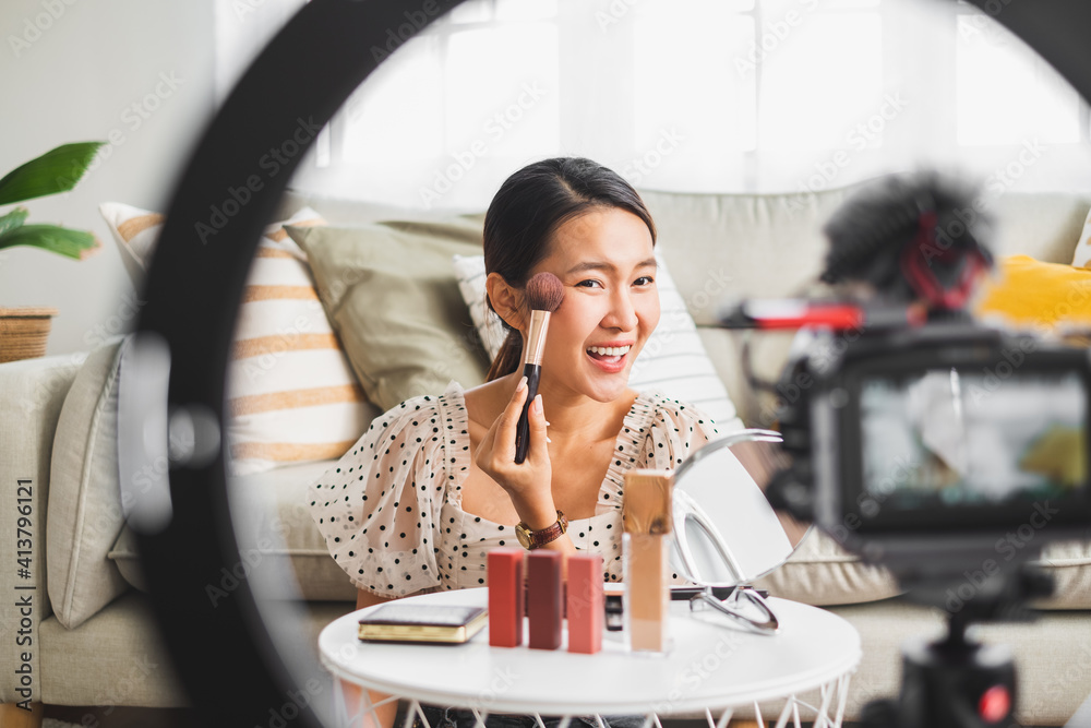 亚洲女性美容博主在社交媒体上直播评论化妆