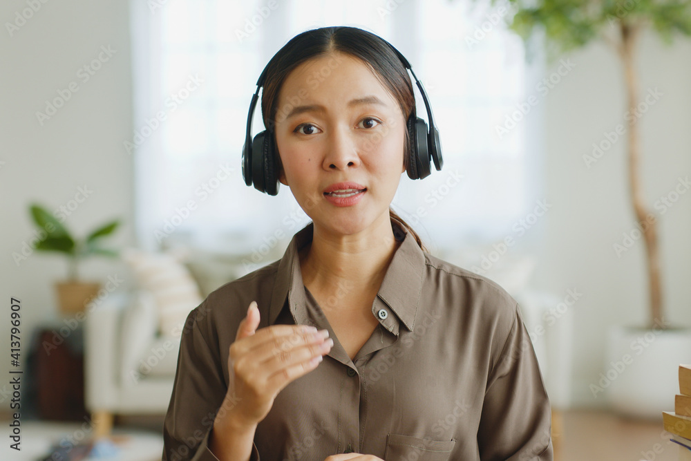 POV亚洲年轻女性戴着耳机在视频电话会议或拉普托虚拟会议上讲话