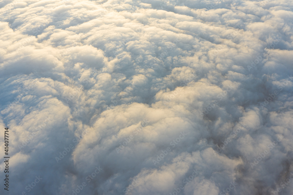 Aerial view from above the clouds during sunrise as seen from a drone.