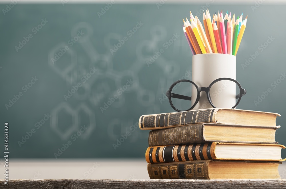 一堆古董书、眼镜和铅笔，教育和学习