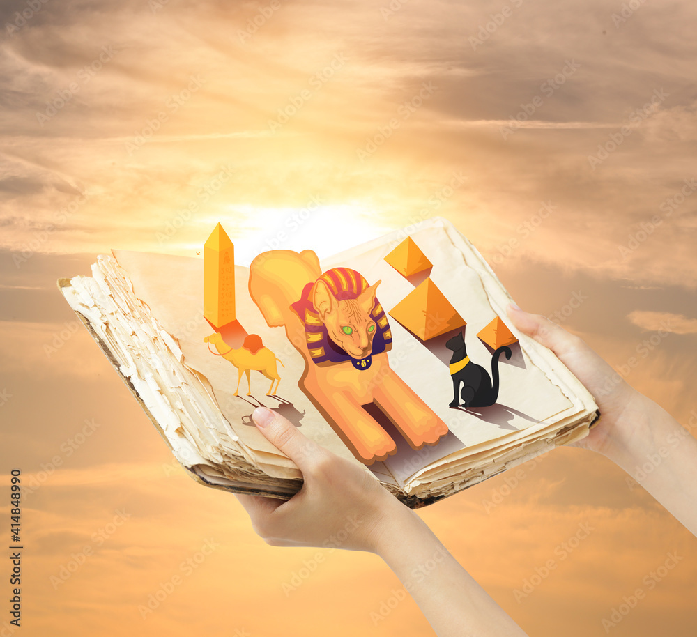 Hands holding book with drawn magic world against sunny sky