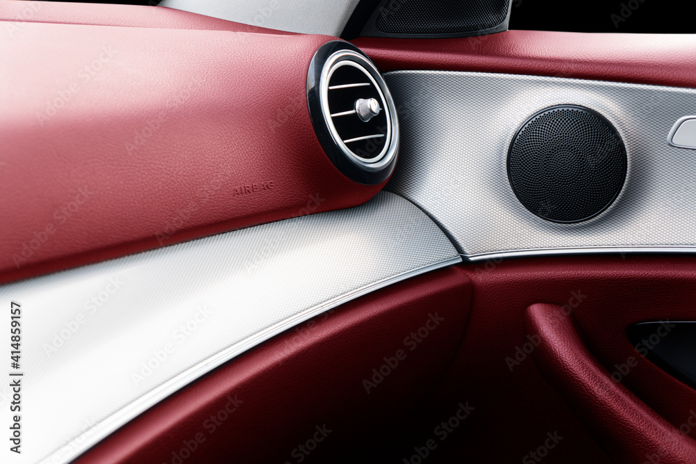 Car door handle inside the luxury modern car with red leather texture with stitching. Switch button 