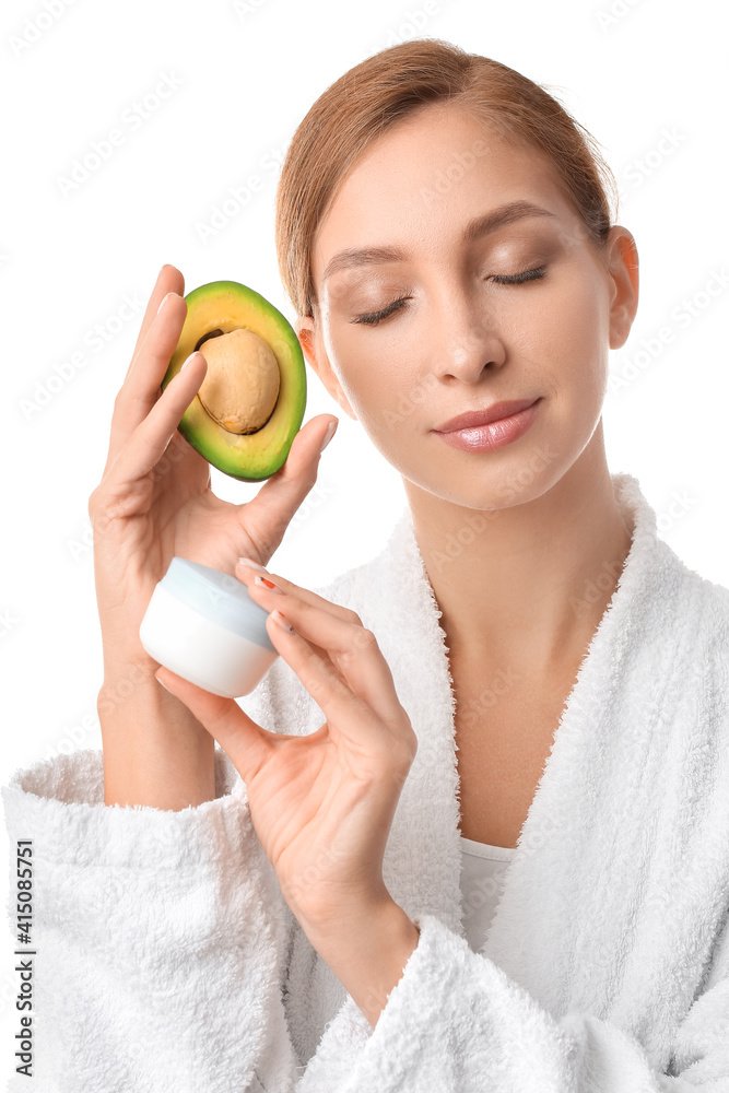 Beautiful young woman with facial cream and avocado on white background