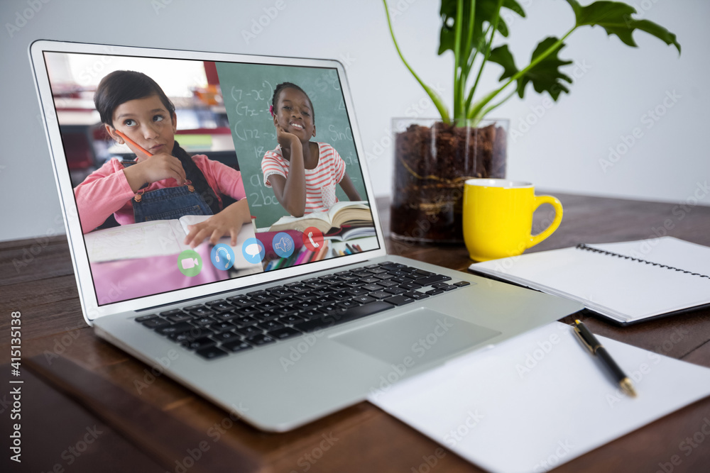 两名女学生在木制桌子上的笔记本电脑上视频会议的网络摄像头视图