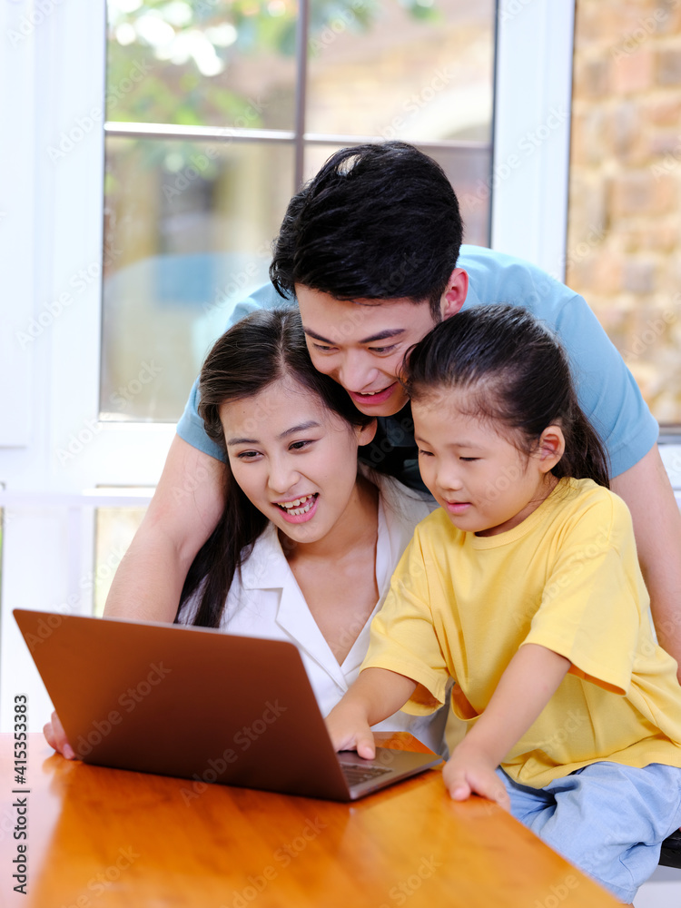 Happy family of three using laptop