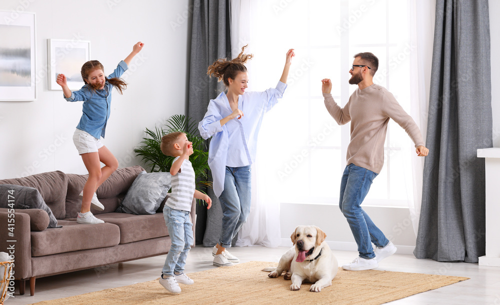 嬉戏的一家人和狗在客厅跳舞