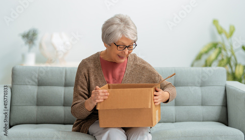 senior woman is holding cardboard box