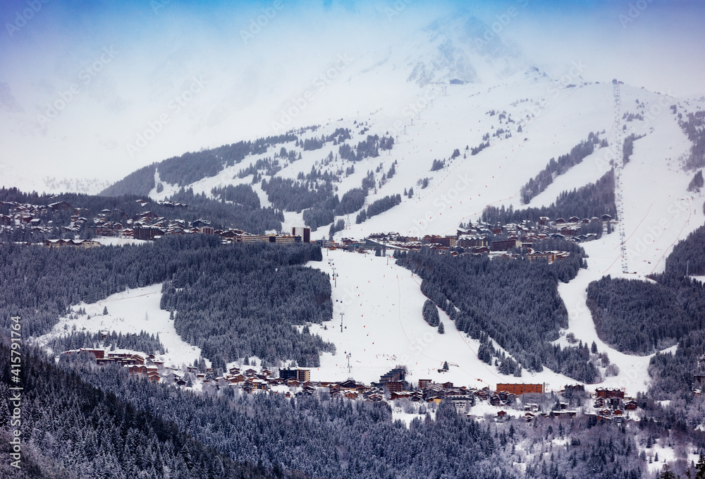Courchevel滑雪场斜坡村、阿尔卑斯山谷、山峰和蓝天的景色