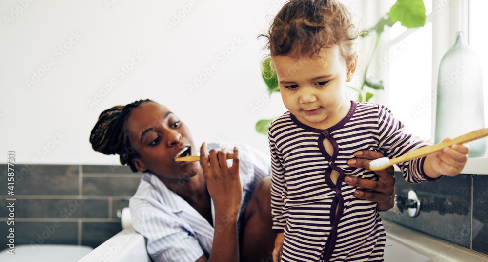 可爱的小女孩和妈妈一起学习刷牙