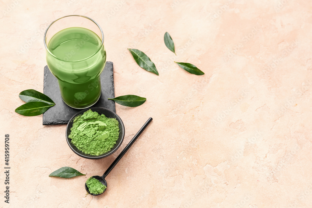 Glass of matcha tea and powder on color background