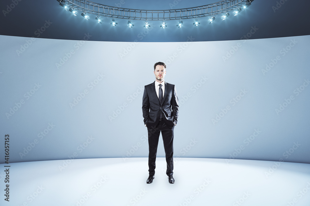 Businessman in black suit in the center of empty light room with led lights