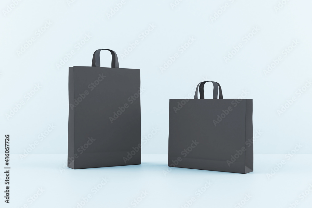 Blank black paper bags with a space for your sign at blue background. Mockup