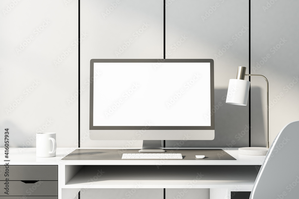 单色风格的家庭工作场所，白色桌子上有白色电脑显示器，位于浅色墙壁背面