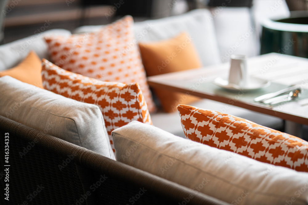 在带有模糊天井区域的自然材质餐椅上布置彩色软枕头垫