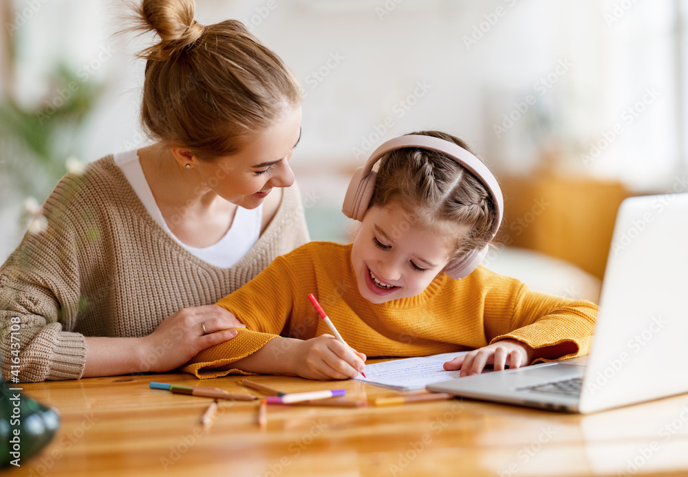 快乐的母亲在网上学习期间支持女儿