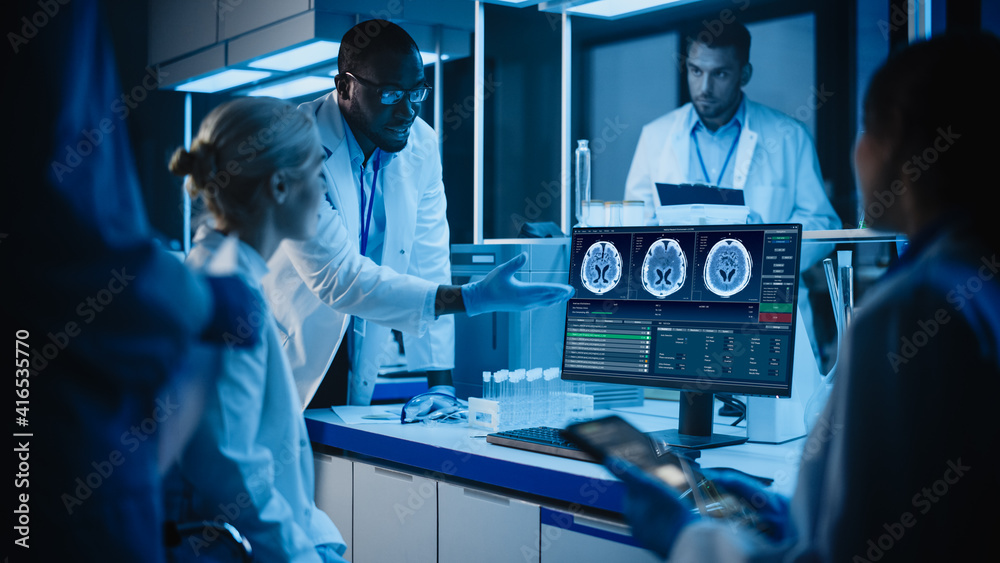 医学研究实验室会议：不同的科学家团队使用计算机显示核磁共振脑扫描