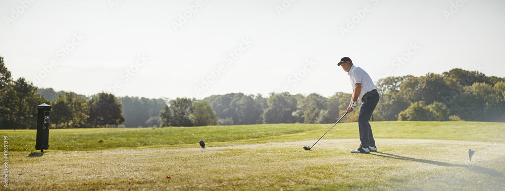 一位老人在打高尔夫球时准备击球