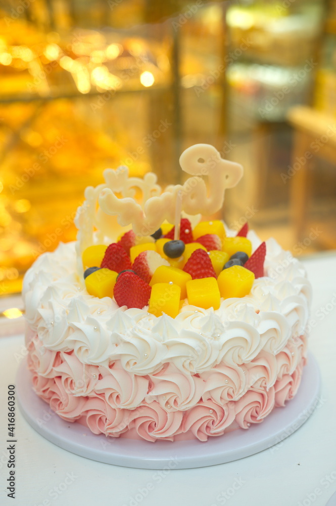 蛋糕店出售的花形奶油装饰的生日蛋糕，有芒果、草莓和布鲁