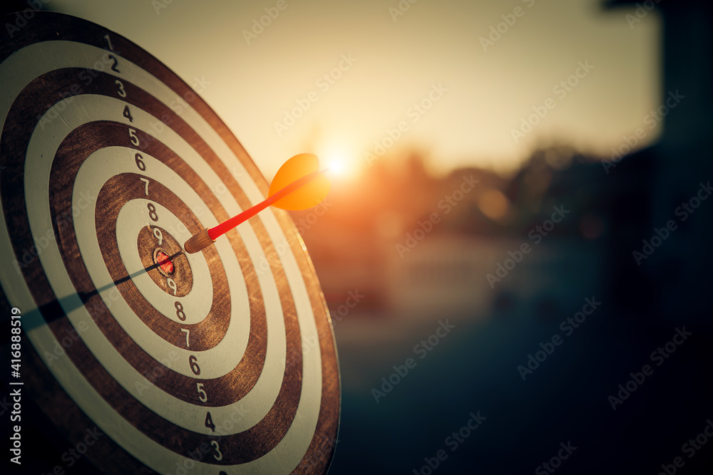 bullseye target or dart board has red dart arrow throw hitting the center of a shooting for business